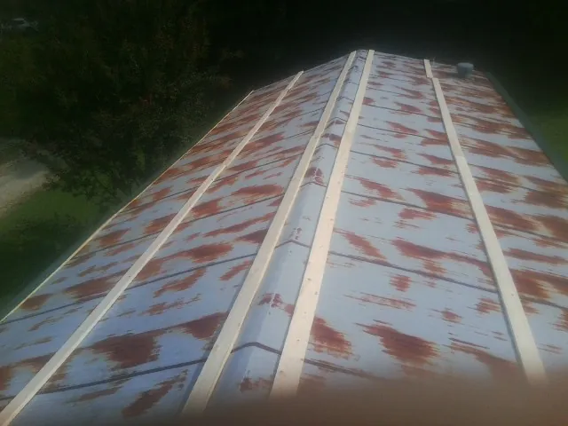 Rusted metal roof panels with new wood purlins before replacement — Storm Damage Roof Repair in Mc Gaheysville by Roofing Brothers